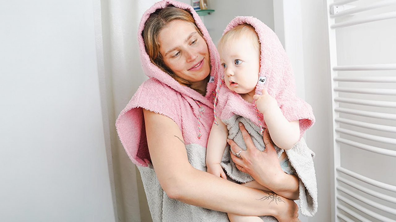 Eine Frau mit einem Baby auf dem Arm im Badezimmer 