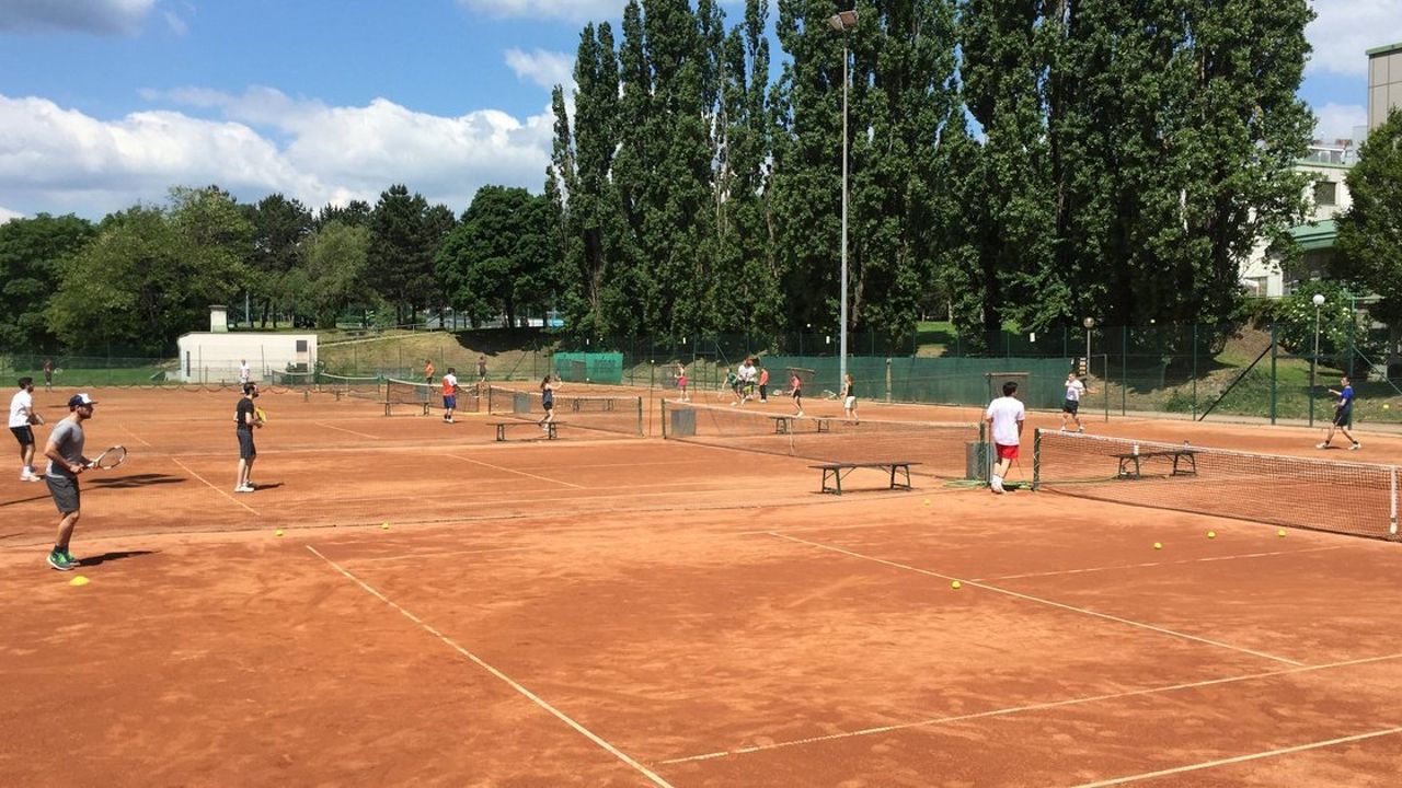 Sandplatz der Tennisanlage Hrubesch mit Spielern im Sonnenschein 