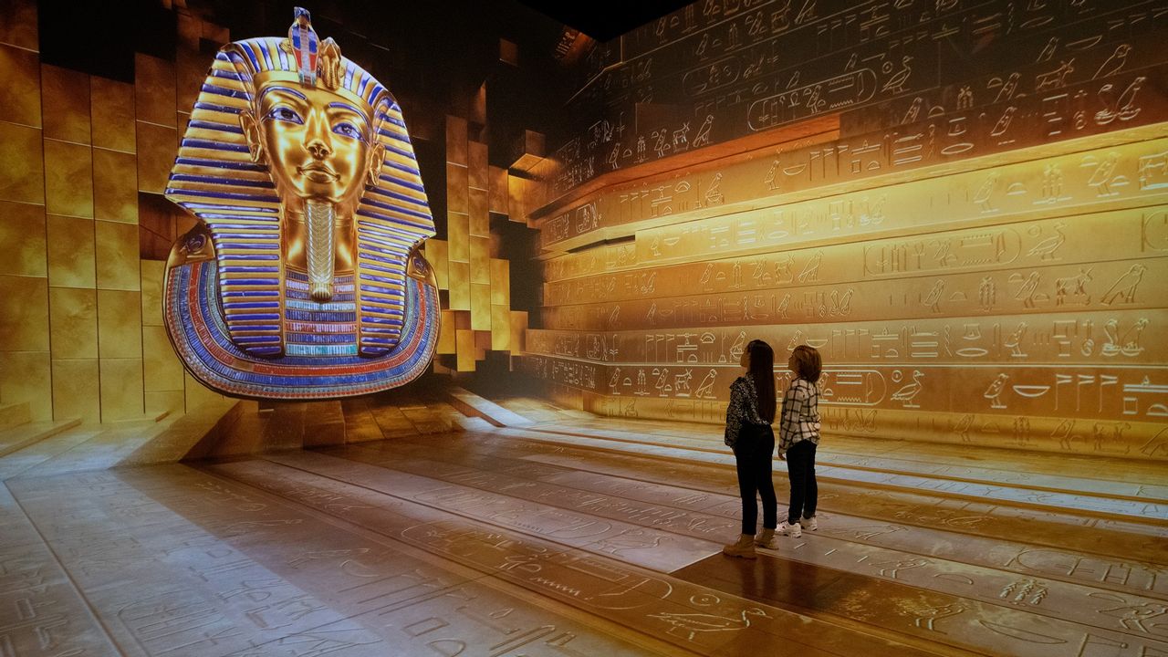 Zwei Kinder vor einer Pharao-Statue