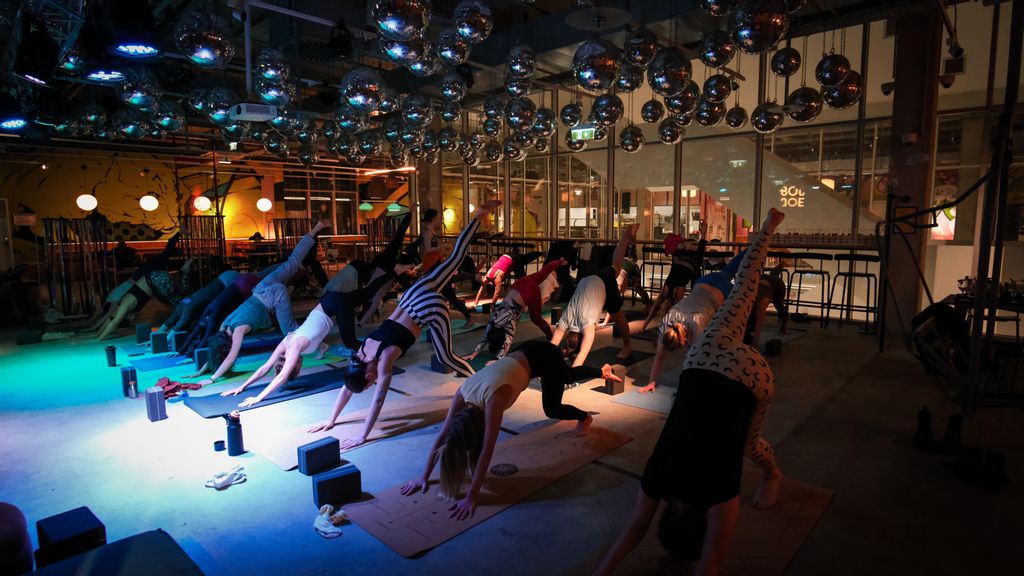 Personen machen Yoga-Übungen in einer Disco