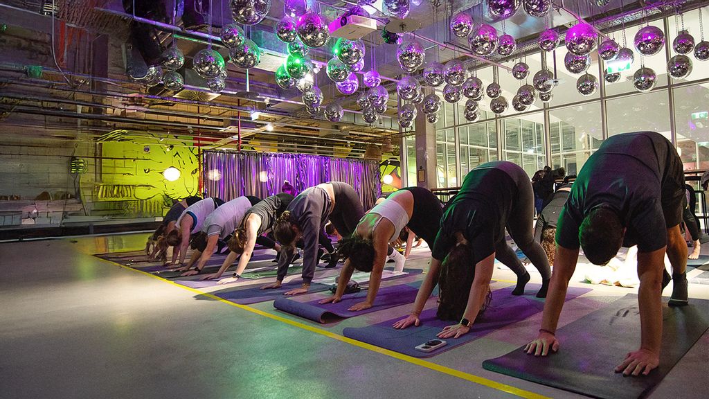 Personen machen Yoga-Übungen unter Discokugeln