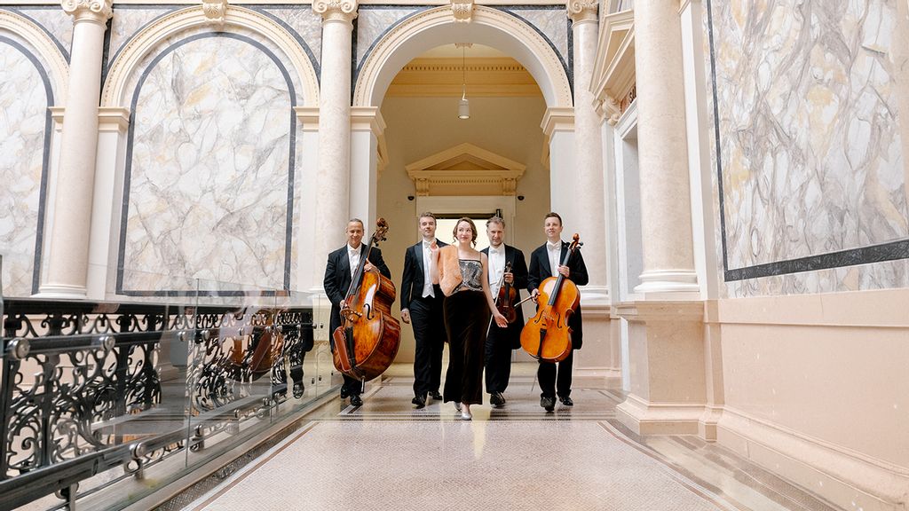 Fünf Musiker*innen mit Streichinstrumenten in einem historischen Gebäude