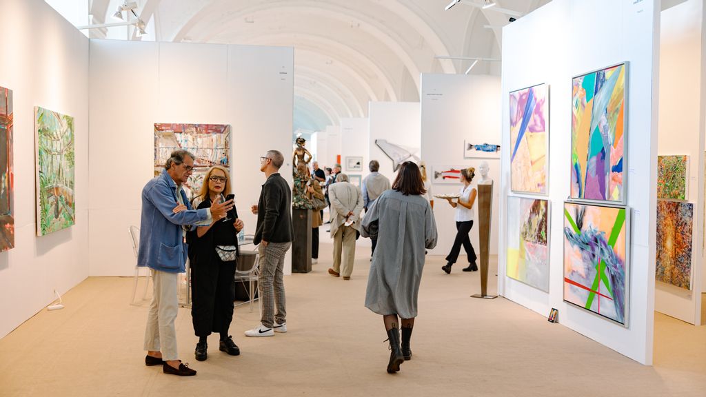 Besucher*innen stehen vor Bildern bei einer Ausstellung 