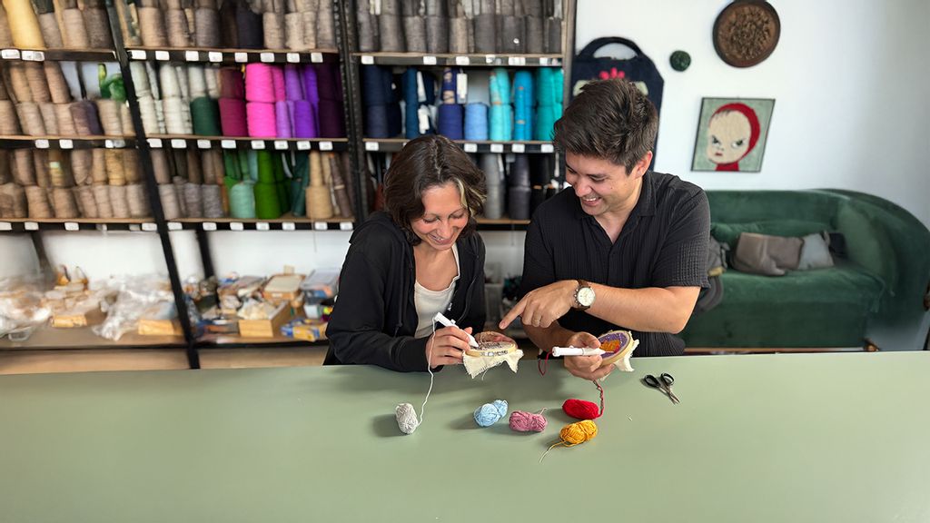 Eine Frau und ein Mann bei einem Workshop, bei dem sie sticken