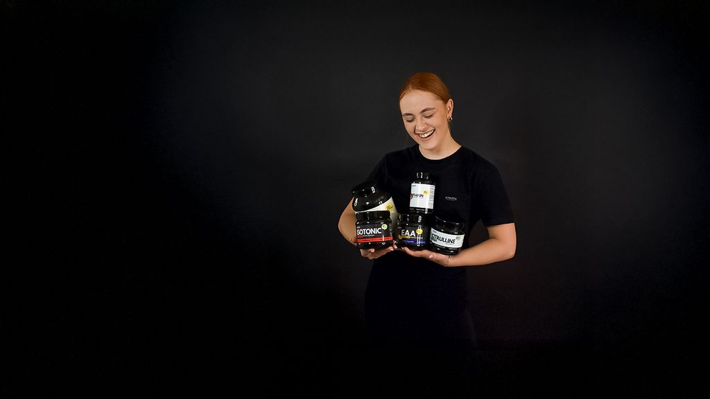 Eine Frau hält unterschiedliche Nahrungsergänzungsmittelprodukte in den Händen