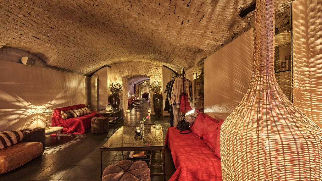 Foyer des orientalischen Hammam Bads mit einem roten Sofa und einer Bodenlampe