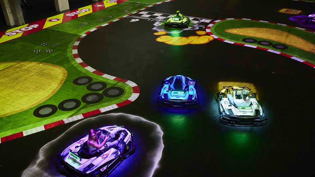 © BattleKart Beleuchtete Karts fahren eine beleuchte Rennstrecke entlang