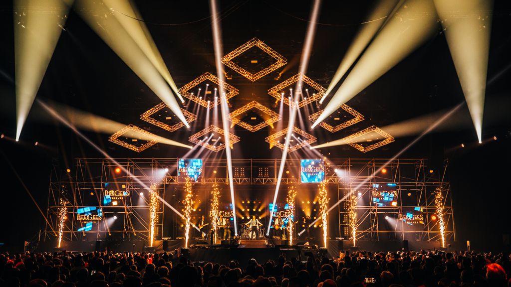 Eine Gruppe an Männern sitzend auf der Bühne bei einem Konzert