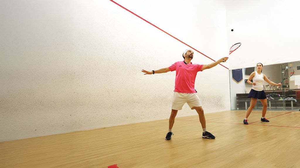 Eine Frau und ein Mann beim Squashspielen