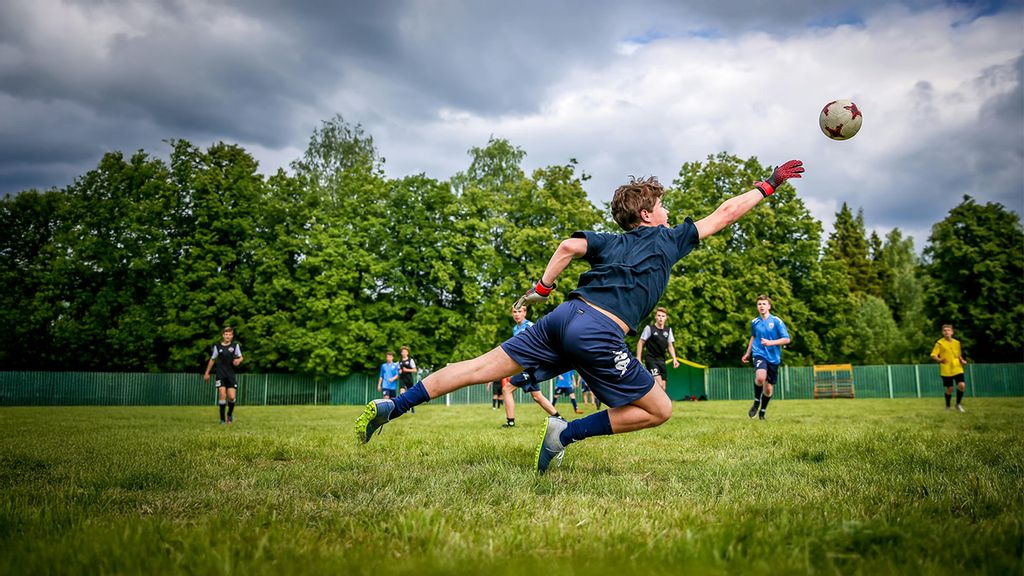 Kinder beim Fußballspielen auf einem Sportplatz