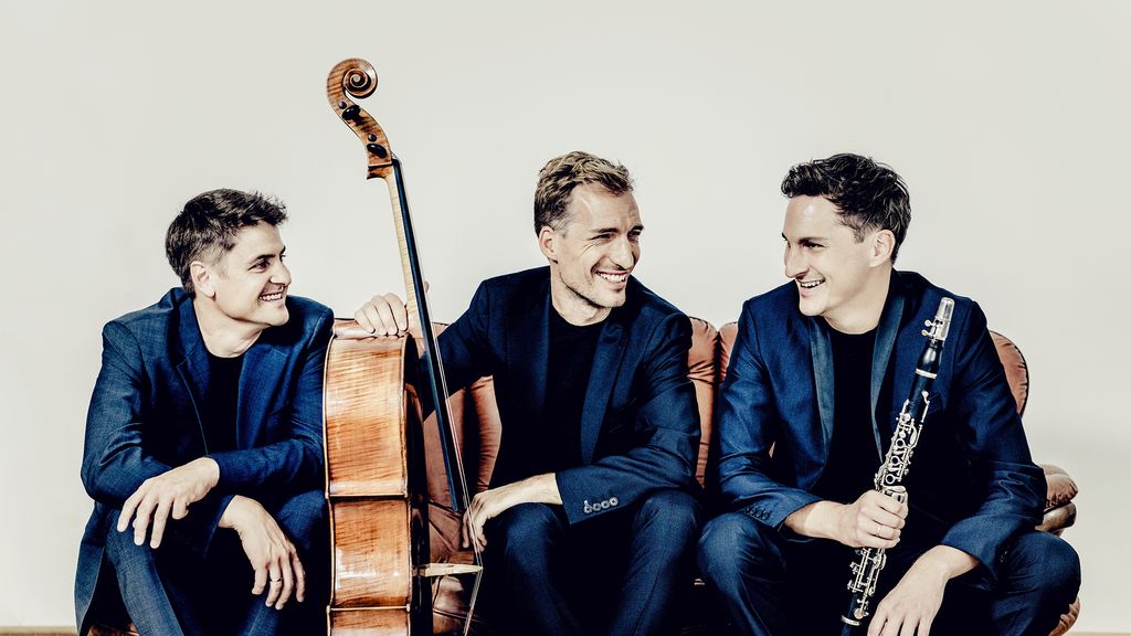 Drei Männer sitzend mit einem Violoncello und einer Klarinette