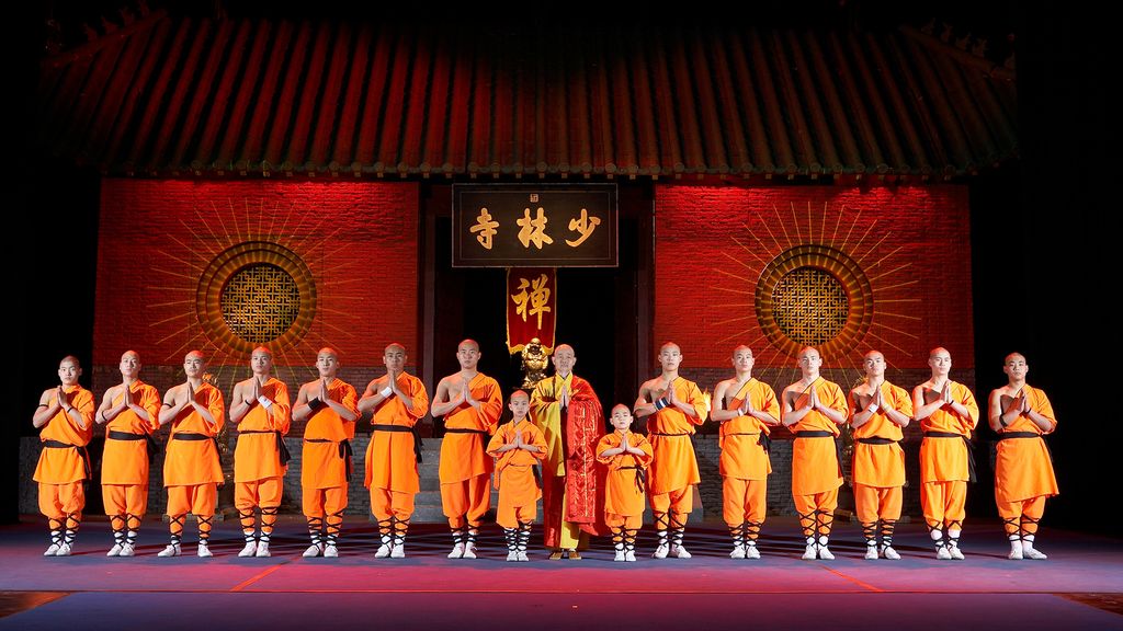 Einige Shaolin Mönche in orangefarbigen traditionellen Roben nebeneinander aufgestellt 