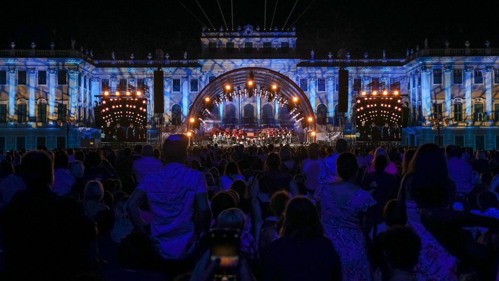 Publikum vor dem beleuchteten Schloss Schönbrunn mit der Bühne im Hintergrund