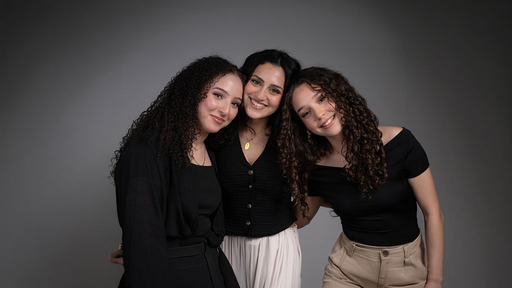 Drei junge Mädchen mit lockigen Haaren bei einem Fotoshooting in einem Studio