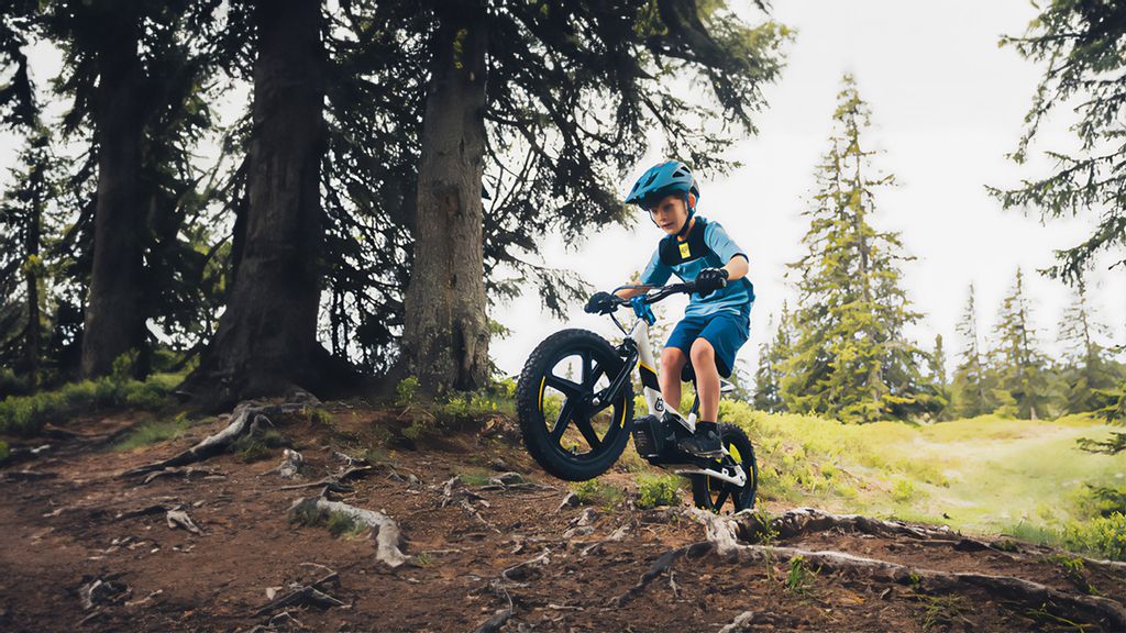 Ein Kinder auf einem Mountainbike fährt im Wald