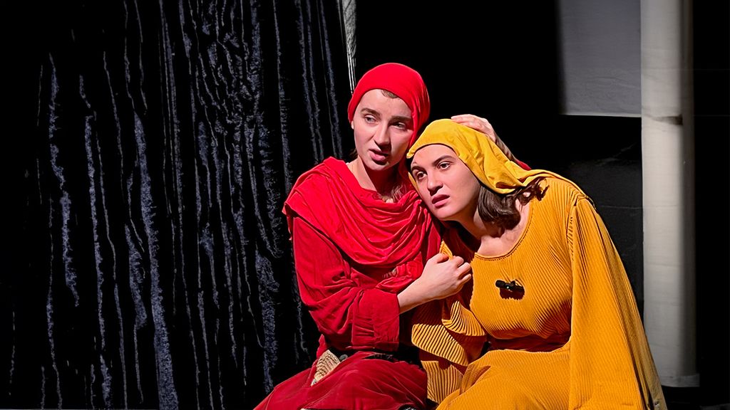 Zwei Schauspieler*innen in roter und orangener Kleidung auf der Bühne