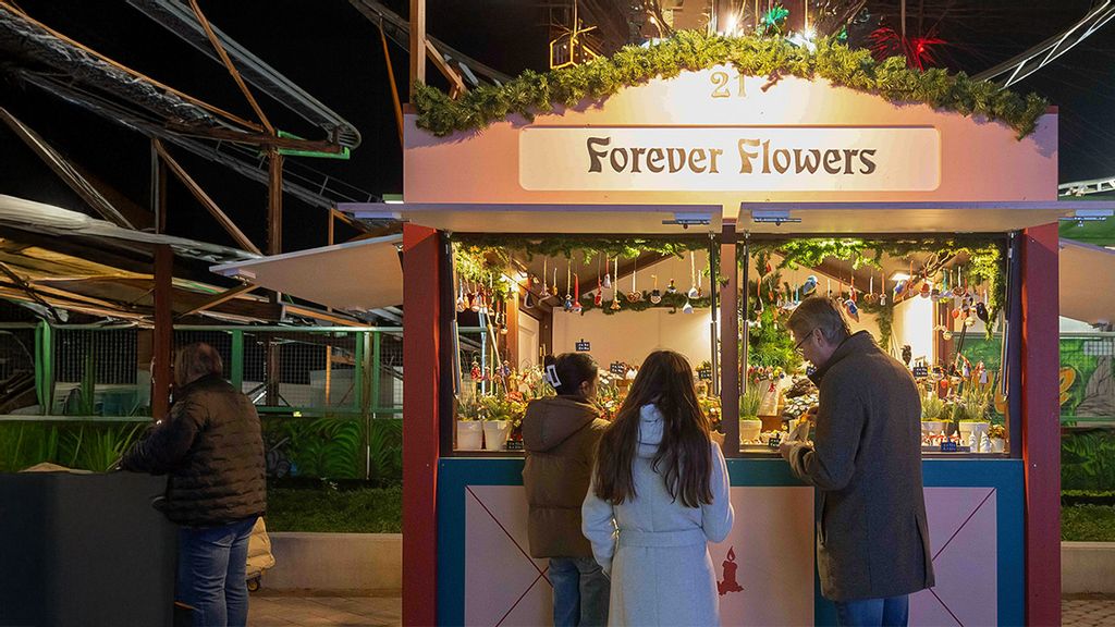 Weihnachtsmarkt-Hütte umgeben von Personen.