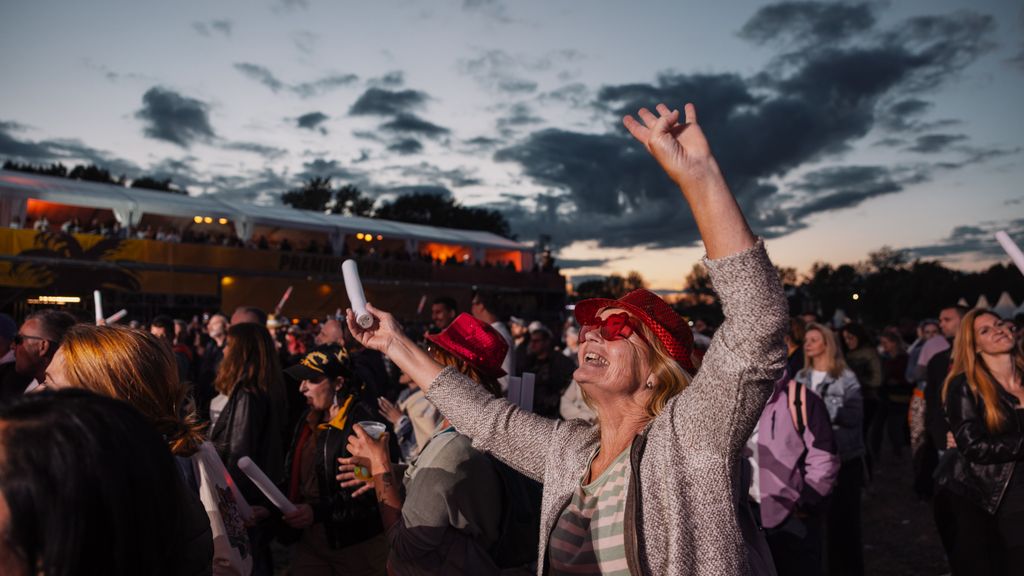 Frau singend in einer Menschenmenge bei einem Festival