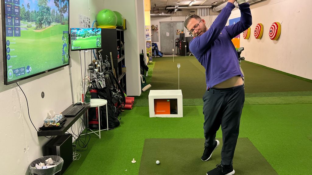 Mann beim Abschlag im Golf Training Indoor Center