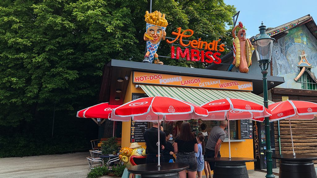 Mehrere Personen vor dem Hot Dog Imbiss Holzhäuschen 