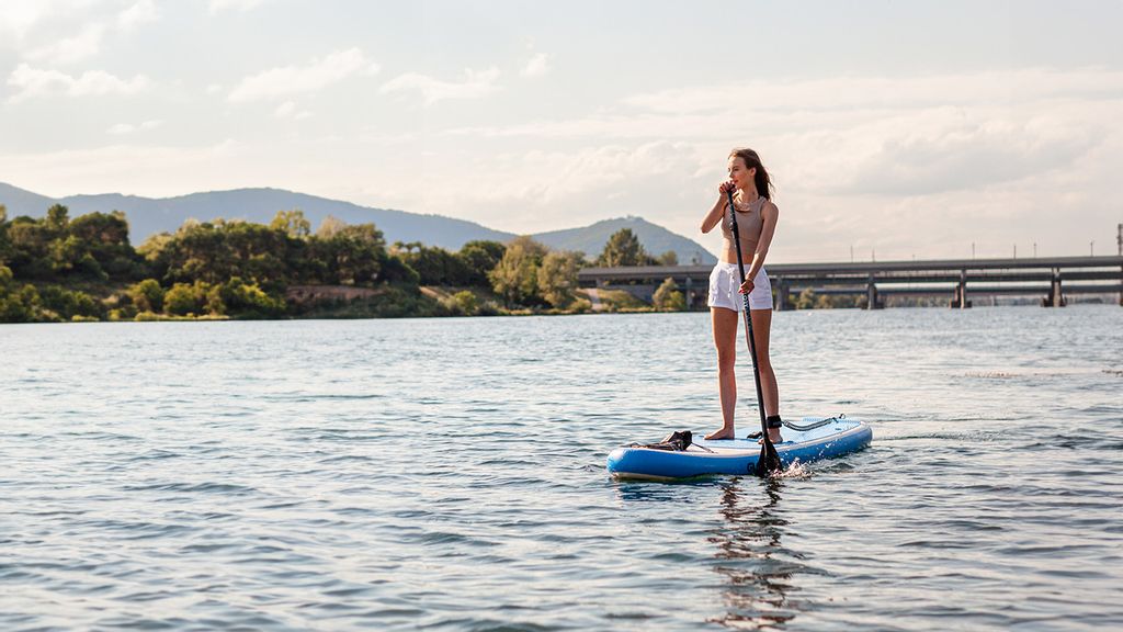 Frau im Sommergewand vor dem Wassersportzentrum