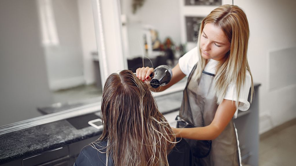 Friseurin föhnt eine Kundin