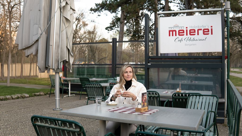 Eine Frau trinkt einen Kaffee in Holzdorfers Meierei