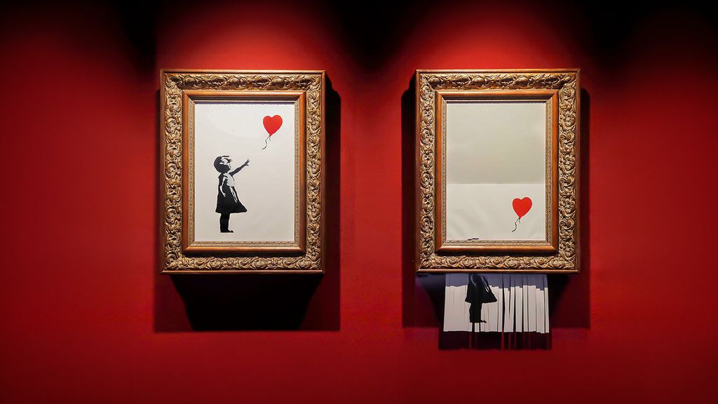 Zwei Kunstwerke vom Künstler Banksy hängen auf einer roten Wand in einem Museum