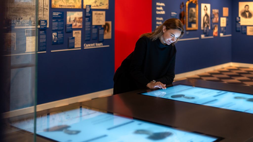 Besucherin steht vor einem Bildschirm im Museum