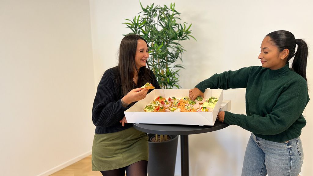 Zwei Frauen mit einem Tablett voller Sandwiches in einem Park
