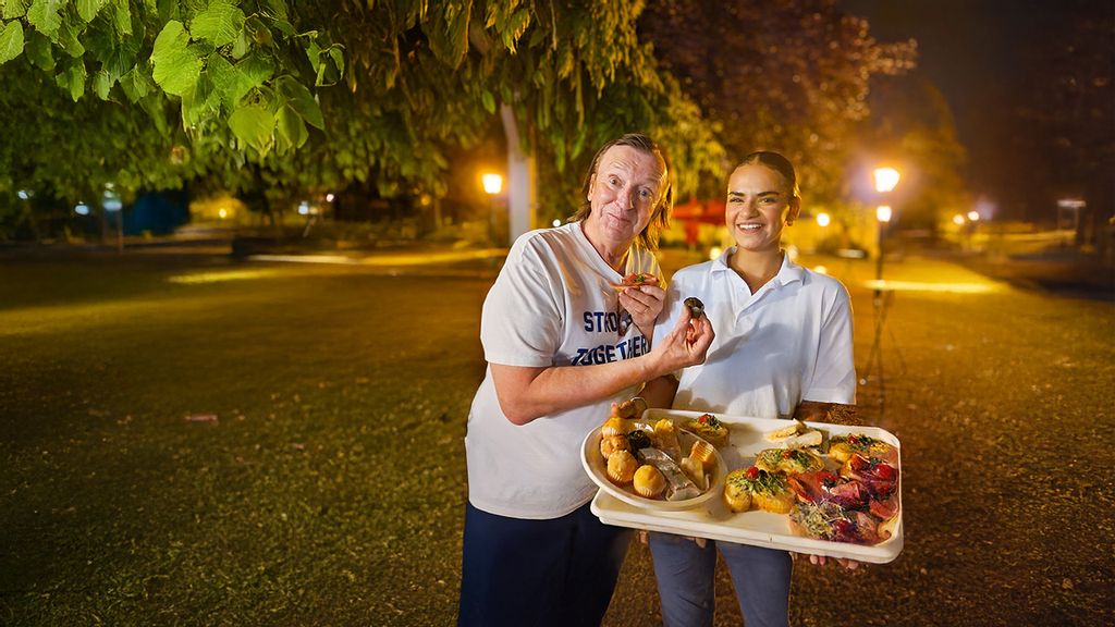 Zwei Frauen mit einem Tablett voller Sandwiches in einem Park