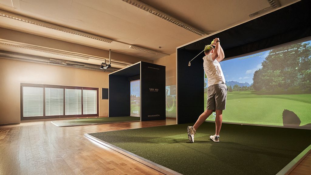 Mann übt Abschlag an einem Golf-Simulator