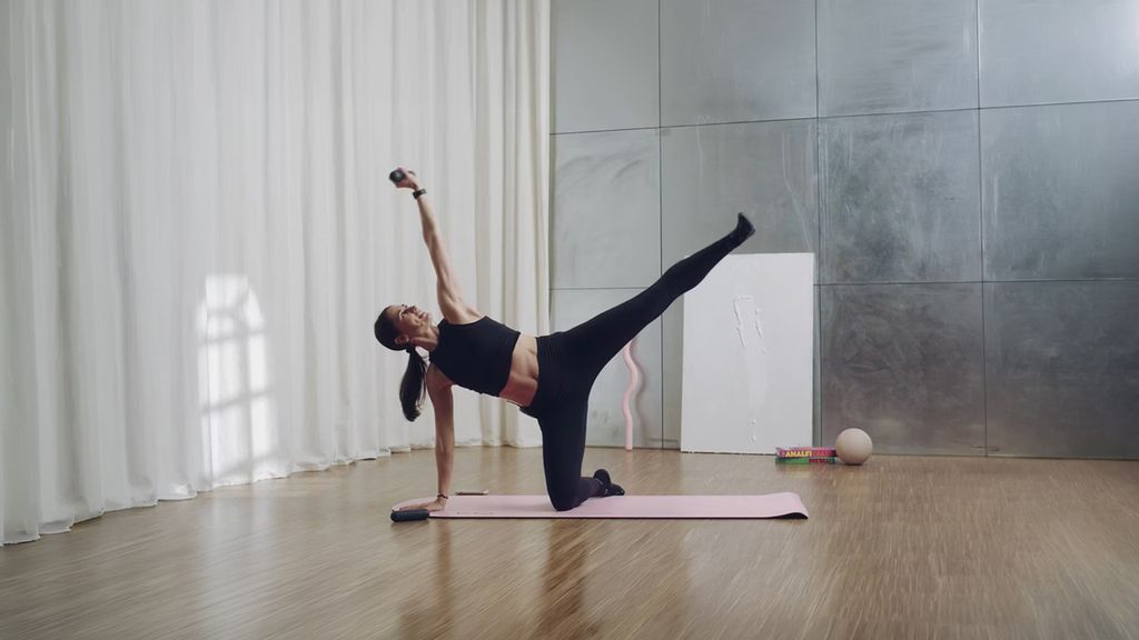 Eine Frau macht Yoga auf einer pinken Matte