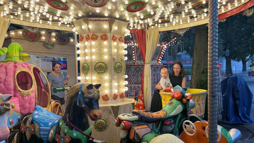 Mutter mit Kind fahren in der Kinderkarussell-Tasse