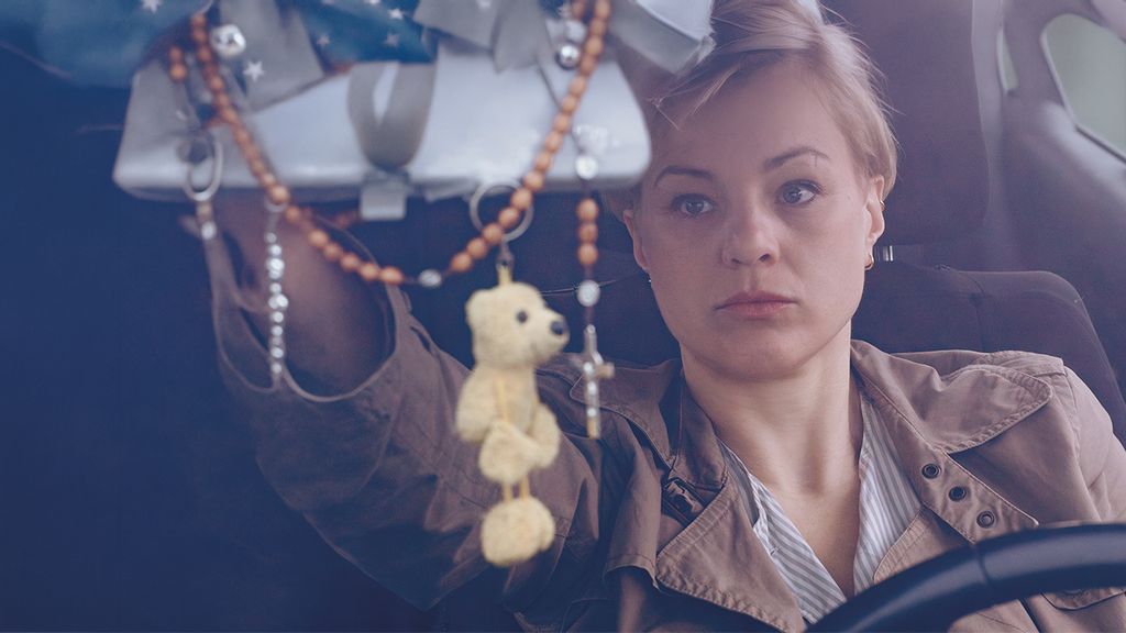 Frau in einem Auto schaut in den Rückspiegel