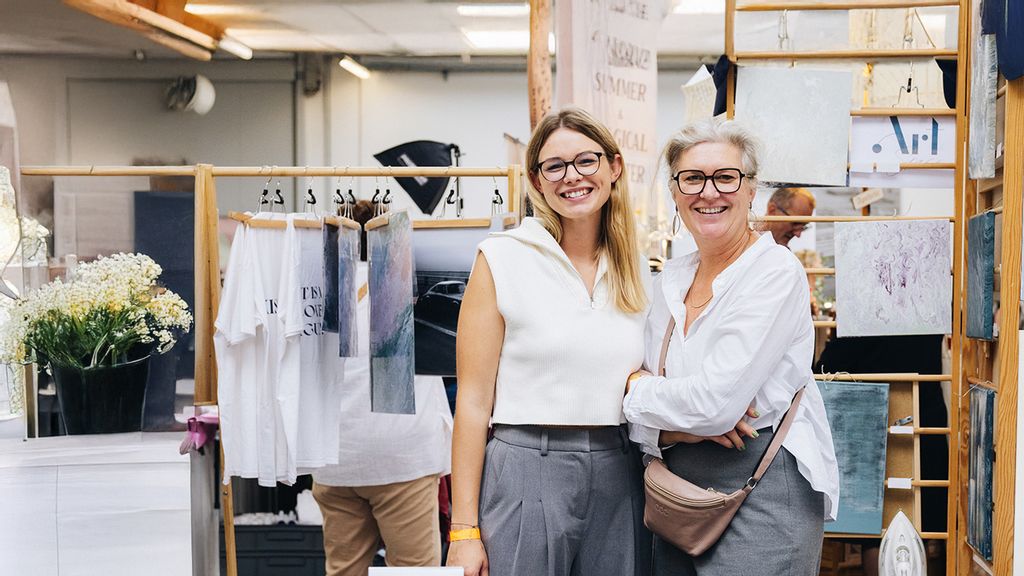 Zwei Besucher*innen des kunst & design markts lächeln in die Kamera