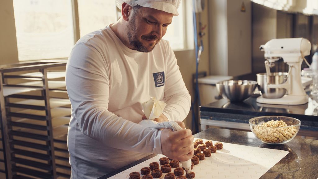 Mann beim Anrichten von Pralinen