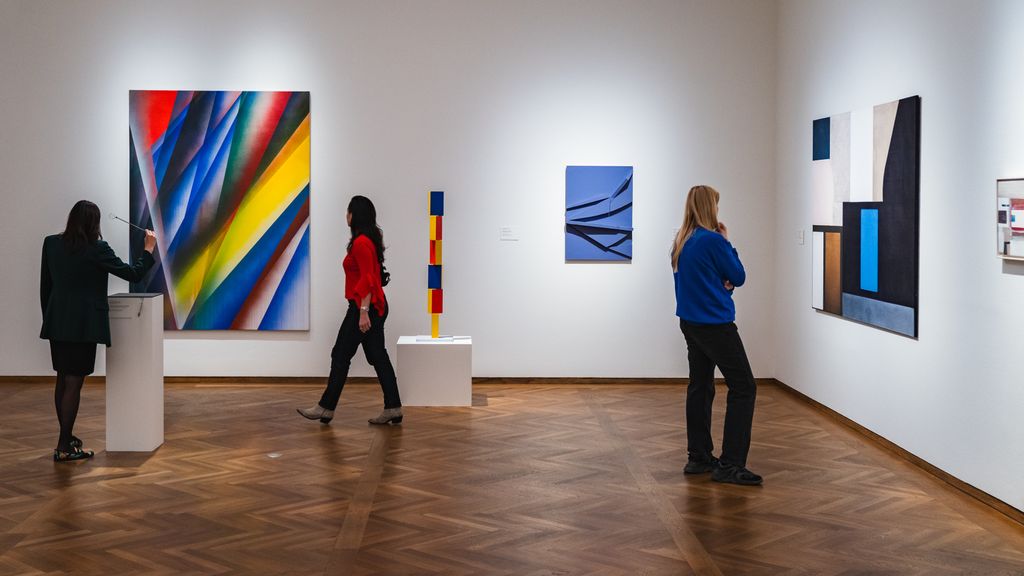 Mehrere Personen in einem Museum vor Gemälden