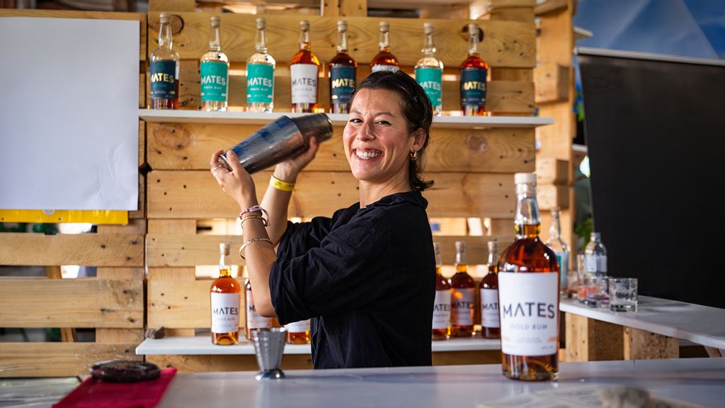 Eine Frau beim Cocktail mixen hinter einer Bar