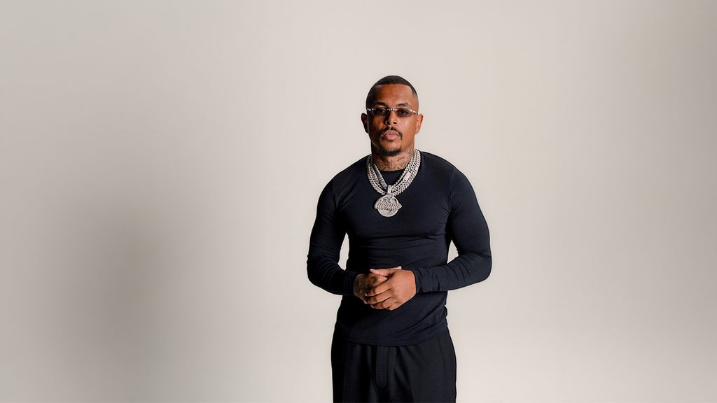 Rapper Luciano in schwarzer Bekleidung vor hellem Hintergrund