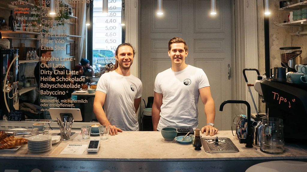 Zwei Männer im Café in weißen T-Shirts