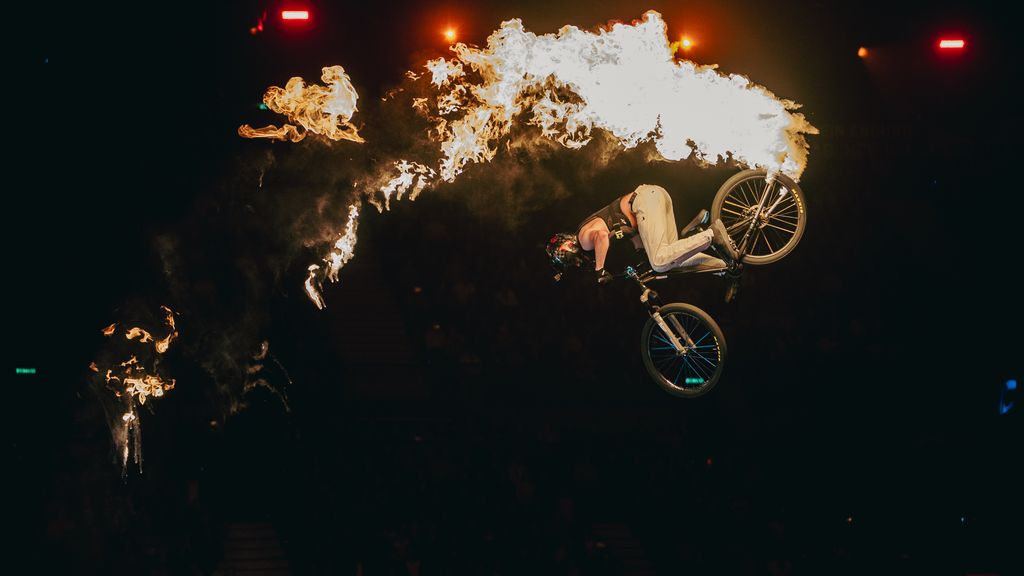 Ein Motorradfahrer, der bei einer Rampe einen Trick ausführt 