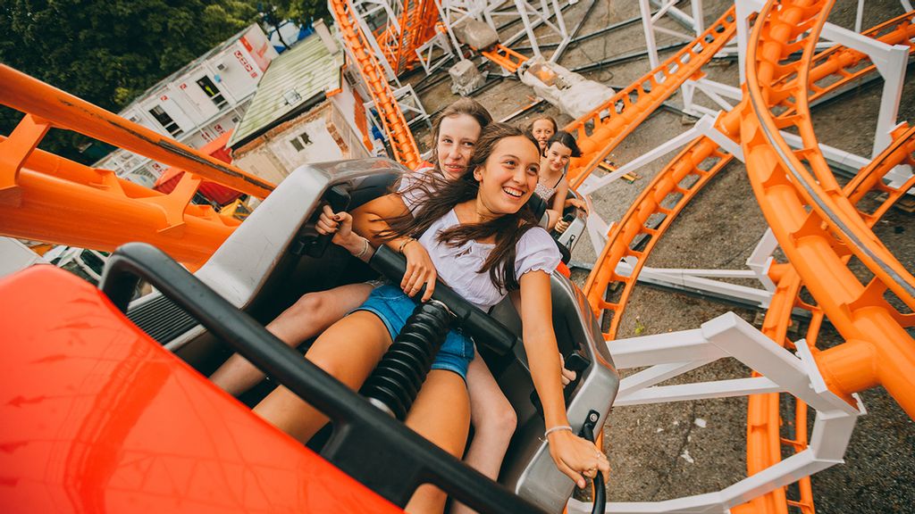 Ein Mädchen und ein Bub fahren auf der Achterbahn