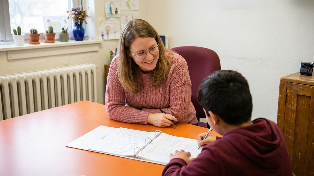 Eine Frau hilft einem Jungen beim Lernen und Lösen einer Aufgabe