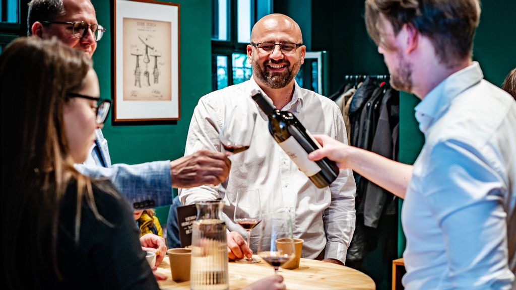 Eine Frau und drei Männer stehen mit einer Sonnenbrille bei einem Weingut