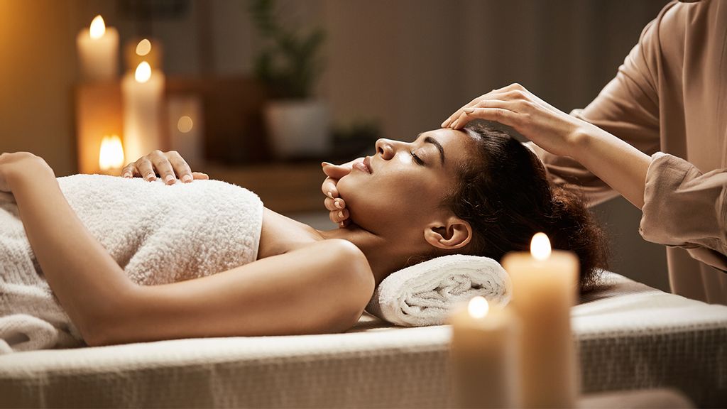 Frau bei einer Gesichtsmassage auf einer Liege