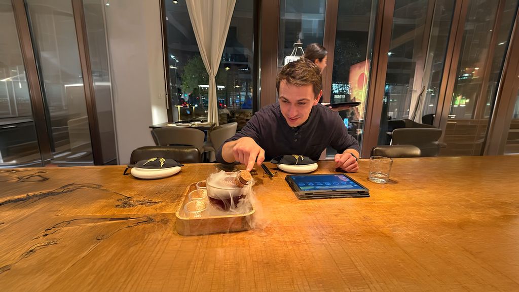 Ein Mann in einem Fine Dining Restaurant zeigt auf das Essen