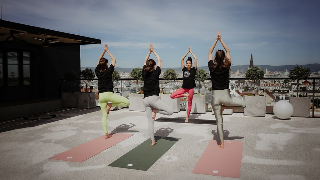 Vier Frauen beim Yoga  auf einer Terrasse