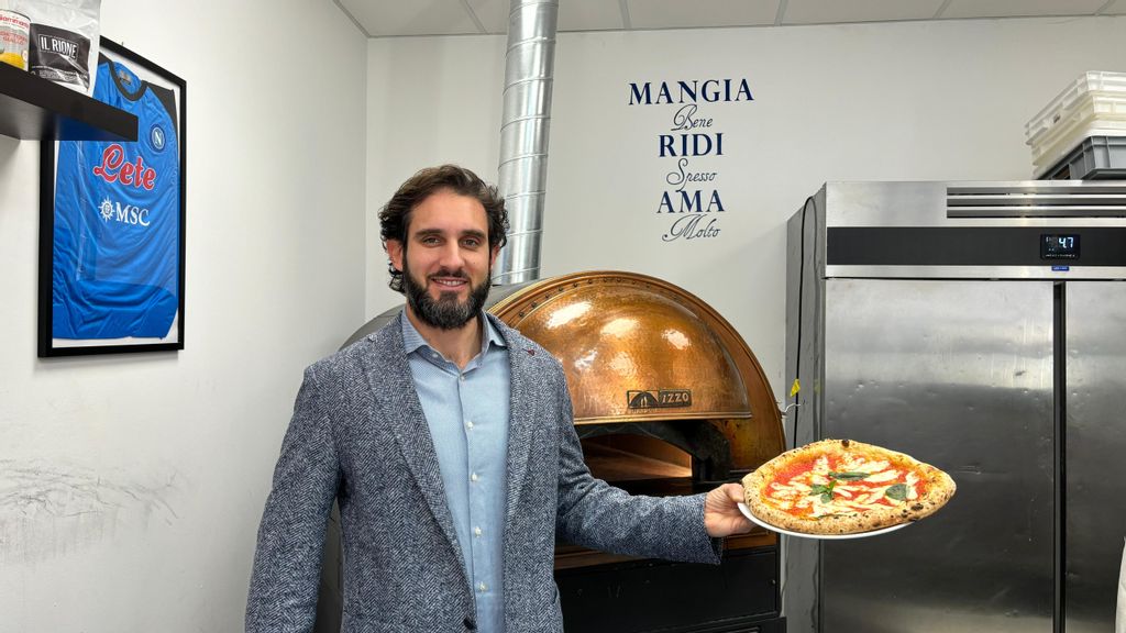 © Geatano Brancato Mann mit einer Pizza in der Hand vor einem Ofen