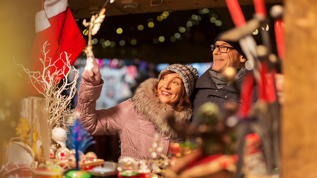 Eine Frau und ein Mann sehen sich bei einem Adventsstand um